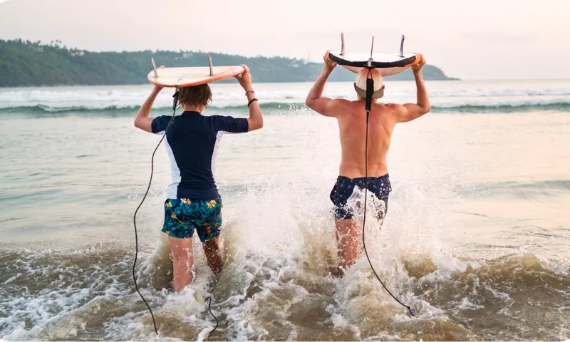 Two surfers running into the waves