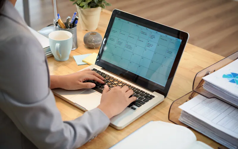 A professional working through reports on a laptop