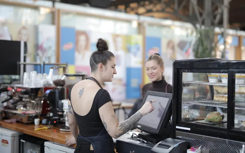 A busy café counter with a point-of-sale screen