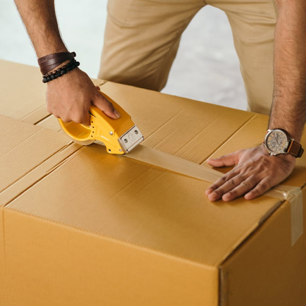 Man sealing a box with tape
